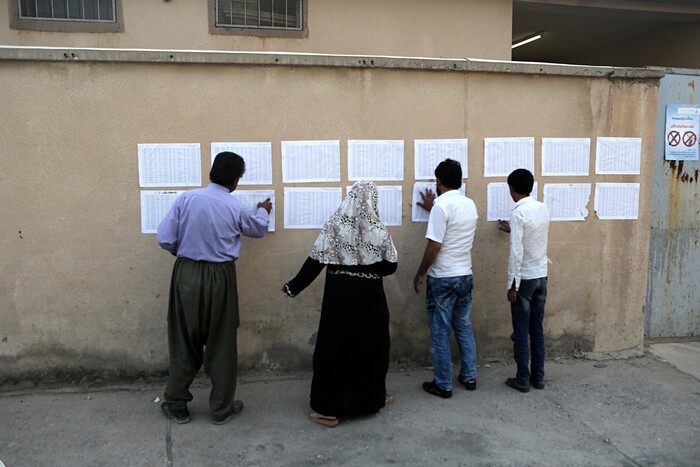 Iraqi Kurdish people check for their names shortly before opening the polling centers for the referendum on independence from Iraq in Irbil, Iraq, Monday, Sept. 25, 2017. (AP Photo/Khalid Mohammed)