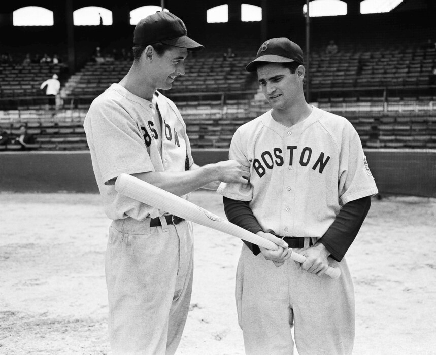 FILE - In this May 14, 1942, file photo, Boston Red Sox left fielder Ted Williams, left, tests the arm of Red Sox second baseman Bobby Doerr before their game against the White Sox, in Chicago. Doerr, a Hall of Fame second baseman who was dubbed the "silent captain" by longtime Red Sox teammate and life-long friend Ted Williams, has died. He was 99. (AP Photo/File)