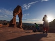 (Leah Hogsten | The Salt Lake Tribune)  Raji Krishnan and Erlen Dsang snap photos of each other at Delicate Arch in Arches National Park as the sun sets, Tuesday, May 16, 2023. In April 2023, Arches National Park implemented a timed entry system to pace visitors' arrival times to alleviate overcrowding and congestion among some 1.8 million visitors a year.