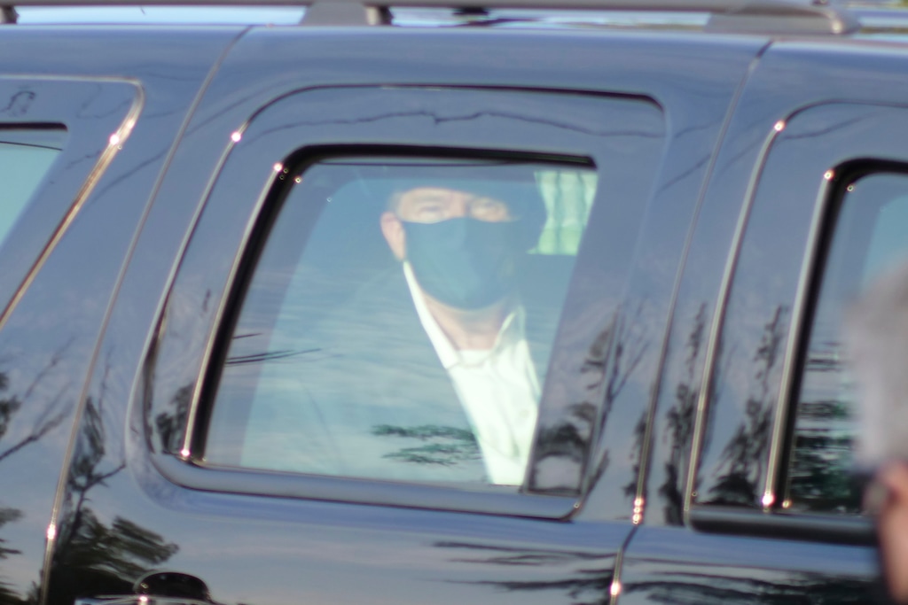 (Anthony Peltier | AP)  President Donald Trump drives past supporters gathered outside Walter Reed National Military Medical Center in Bethesda, Md., Sunday, Oct. 4, 2020. Trump was admitted to the hospital after contracting COVID-19.