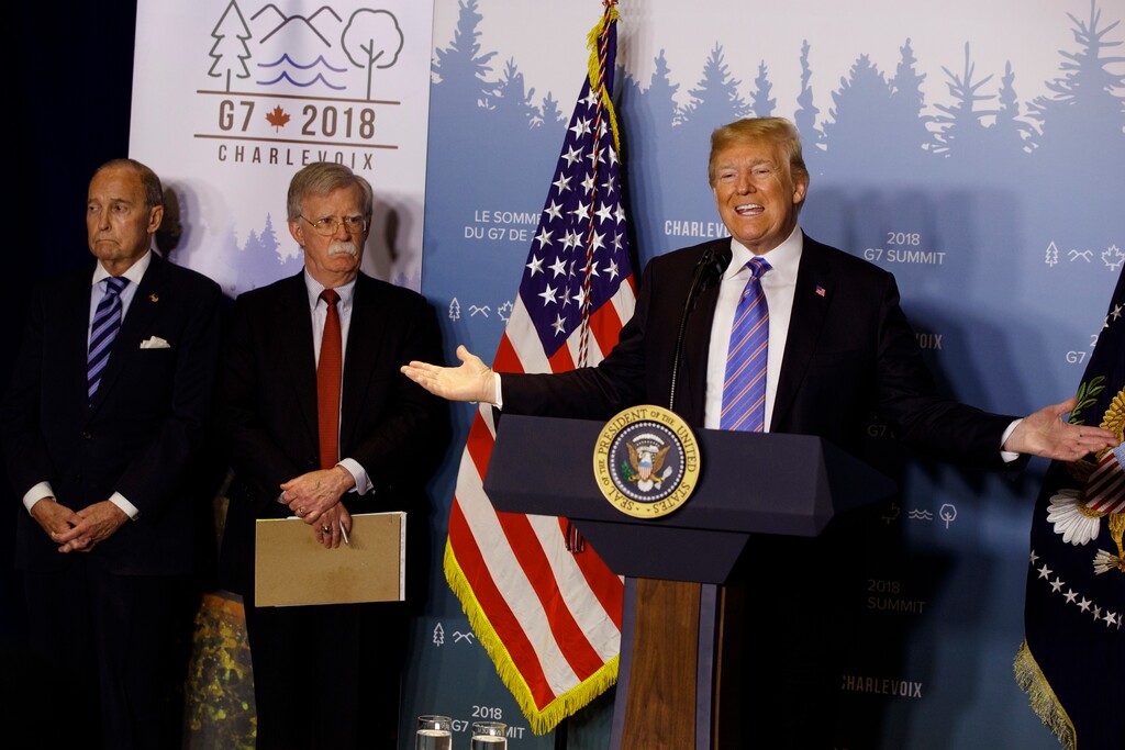 (Evan Vucci | The Associated Press) White House chief economic adviser Larry Kudlow, left, and National Security Adviser John Bolton look on as President Donald Trump speaks during a news conference at the G-7 summit, Saturday, June 9, 2018, in La Malbaie, Quebec, Canada.