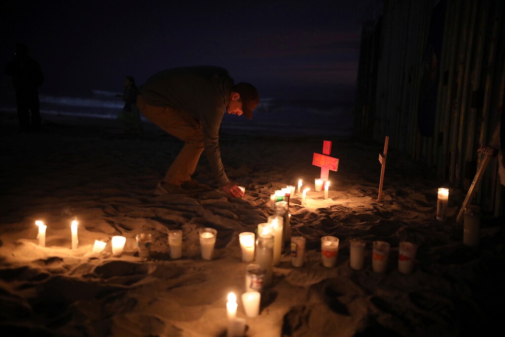 Candles are placed next to the border fence that separates Mexico from the United States, in memory of migrants who have died during their journey toward the U.S., in Tijuana, Mexico, late Saturday, June 29, 2019. (AP Photo/Emilio Espejel)