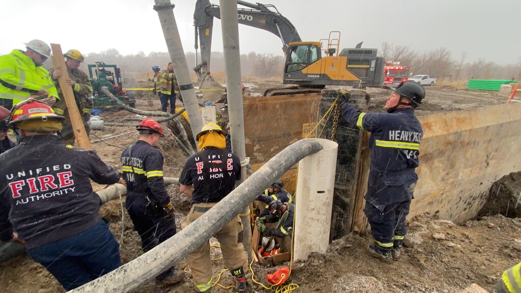 (Courtesy of the Unified Fire Authority) Firefighters work to remove dirt trapping a construction worker.
