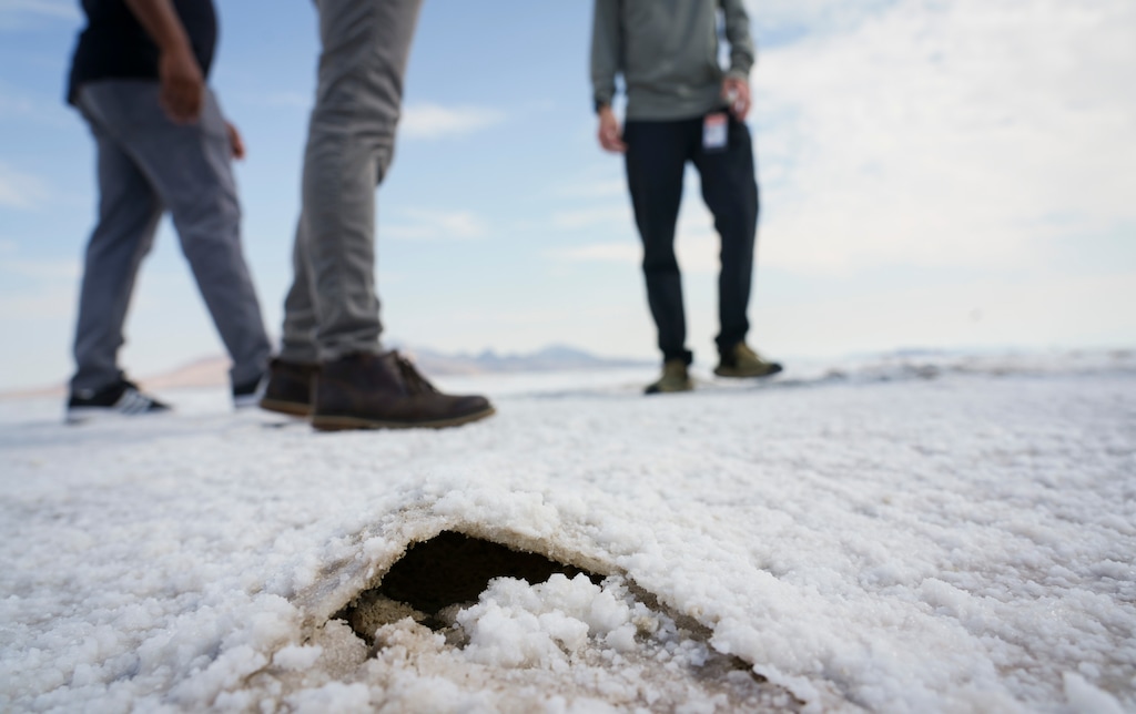(Bethany Baker | The Salt Lake Tribune) People stand near a buckle in the thinning layer of salt at the Bonneville Salt Flats near Wendover on Friday, Sept. 5, 2025.