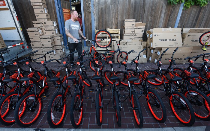 (Francisco Kjolseth  |  The Salt Lake Tribune)  Simon Harris a youth program coordinator for Bike Utah joins other volunteers and workers at Squatter's Pub Brewery to assemble 80 bicycles on Tuesday, May 29, 2018, at the brewery which will be given away to 1st and 2nd graders at Washington Elementary on Wednesday. Part of the program is backed by the Can'd Aid Foundation.