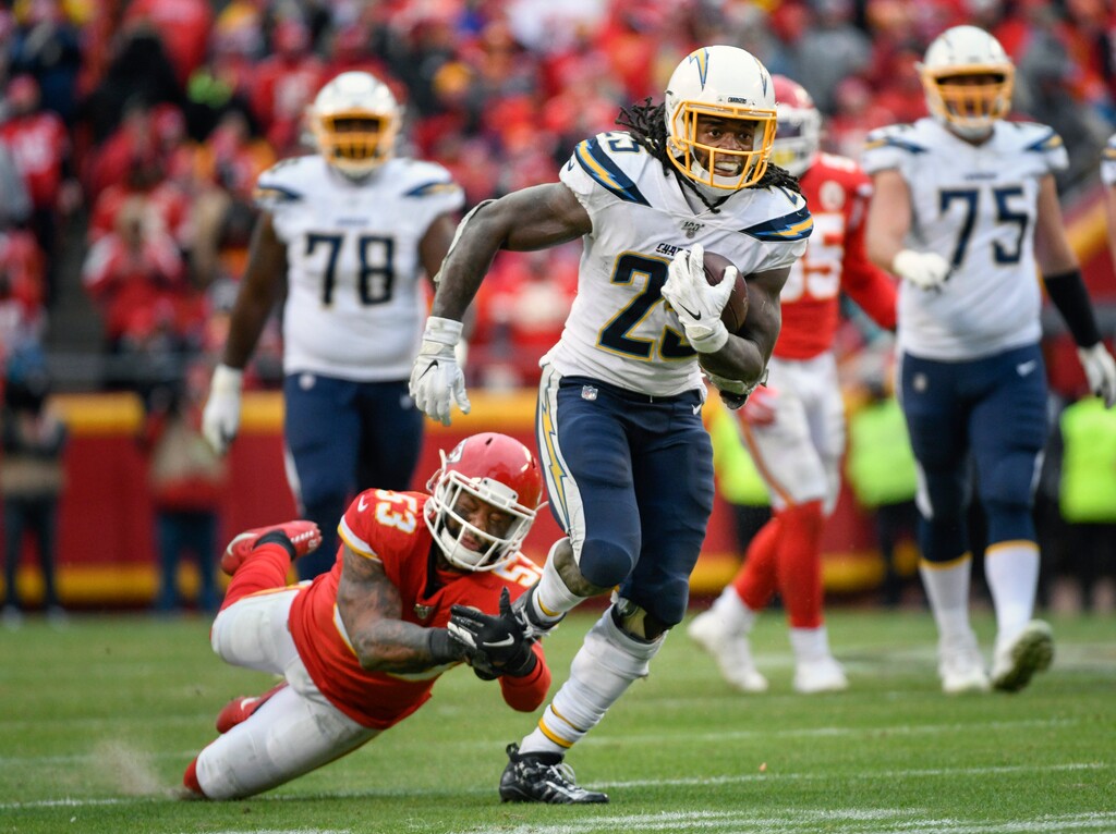 FILE - In this Dec. 29, 2019, file photo, Los Angeles Chargers running back Melvin Gordon (25) runs past Kansas City Chiefs inside linebacker Anthony Hitchens (53) during the second half of an NFL football game in Kansas City, Mo. The Denver Broncos continued an impressive offseason haul Friday, March 20, 2020, by agreeing to a two-year deal with former Los Angeles Chargers running back Melvin Gordon. (AP Photo/Reed Hoffmann, File)