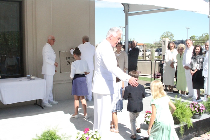 ( Courtesy photo | The Church of Jesus Christ of the Latter-day Saints) .Uchtdorf helps LDS children place mortar around the cornerstone.
