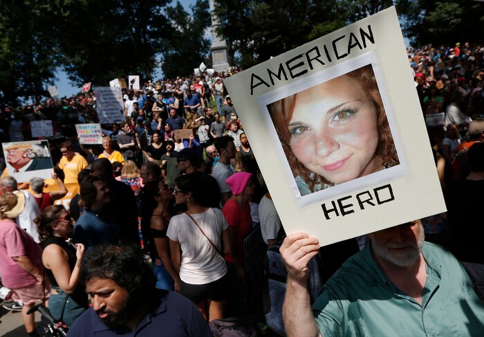 A counterprotester holds a photo of Heather Heyer on Boston Common at a "Free Speech" rally organized by conservative activists, Saturday, Aug. 19, 2017, in Boston. Heyer was killed last Saturday when a car, allegedly driven by James Alex Fields Jr., that plowed into a group of people during protests in Charlottesville, Va. (AP Photo/Michael Dwyer)