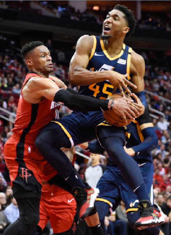 Utah Jazz guard Donovan Mitchell (45) is wrapped up by Houston Rockets guard Russell Westbrook during the second half of an NBA basketball game, Sunday, Feb. 9, 2020, in Houston. (AP Photo/Eric Christian Smith)
