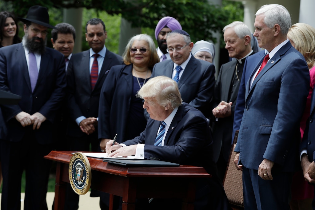 President Donald Trump signs an executive order in the Rose Garden of the of the White House in Washington, Thursday, May 4, 2017, asking the IRS to use "maximum enforcement discretion" over the regulation, known as Johnson Amendment, which applies to churches and nonprofits (AP Photo/Evan Vucci)