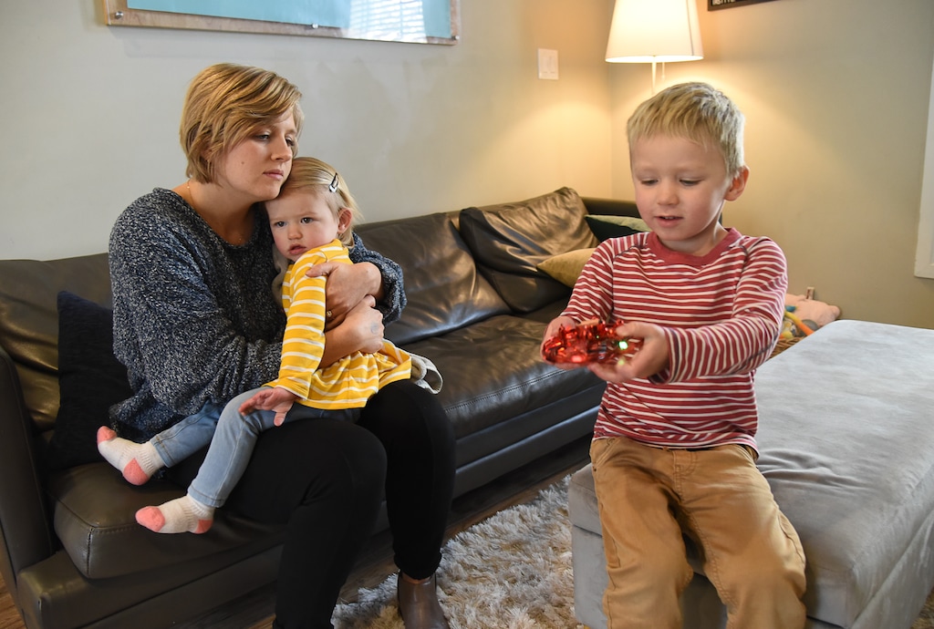 (Francisco Kjolseth  |  The Salt Lake Tribune)  Nile Checketts embraces her 18-month-old daughter Valentine as her son Wesley, 4, plays with a new birthday toy at their home in Salt Lake City on Monday, Dec. 9, 2019.