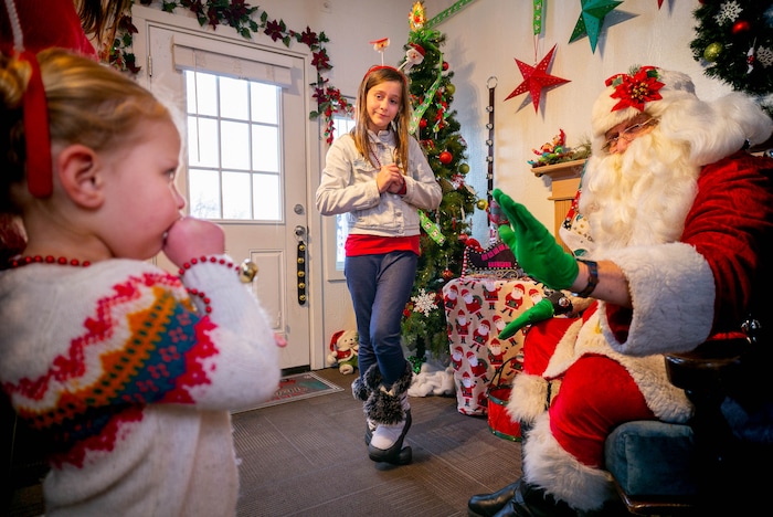 (Trent Nelson | The Salt Lake Tribune) Anabelle Sorenson, left, is a little nervous visiting Santa at the Sugar House Santa Shack in Salt Lake City on Friday, Dec. 20, 2019. At center is Teija LeGrande.