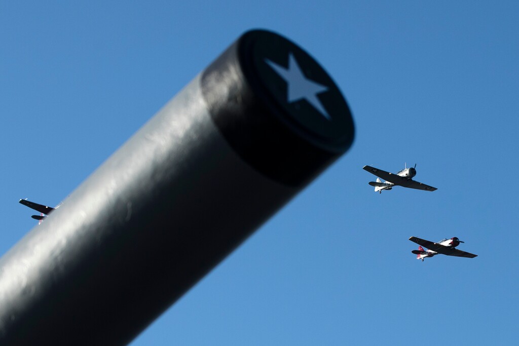 World War II era T-6 Texan trainer aircraft flyover The Battleship New Jersey Museum and Memorial in Camden, N.J., during a ceremony commemorating the anniversary of the Dec. 7, 1941 Japanese attack on Pearl Harbor, Thursday, Dec. 7, 2017. (AP Photo/Matt Rourke)