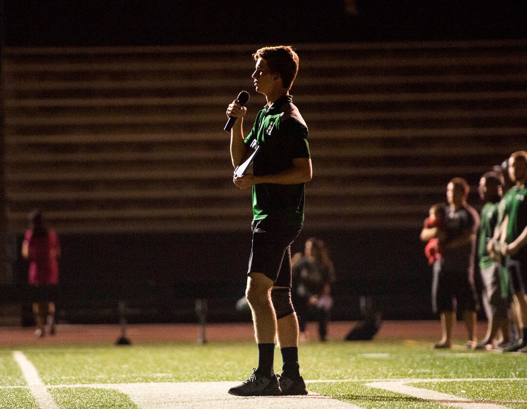 (Rick Egan  |  The Salt Lake Tribune)Hillcrest football player Brody Roerich holds a photo of Coach Cazzie Brown, as he says a few words at a candlelight vigil in honor of coach Cazzie Brown, at Hillcrest High School, Monday, August 28, 2017.