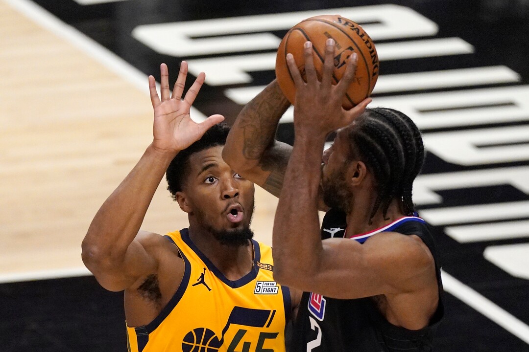 Los Angeles Clippers forward Kawhi Leonard, right, tries to pass while under pressure from Utah Jazz guard Donovan Mitchell during the first half in Game 4 of a second-round NBA basketball playoff series Monday, June 14, 2021, in Los Angeles. (AP Photo/Mark J. Terrill)