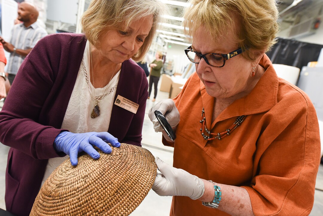 (Francisco Kjolseth  |  The Salt Lake Tribune)  Glenna Nielsen-Grimm, an anthropologist with collections and research at the Natural History Museum of Utah, left, and   anthropologist Catherine Sweeney Fowler from the University of Nevada, Reno inspect the coiling weave structure of a well used Ute tribe basket that was collected by John Wesley Powell, well known in Utah for his famed Colorado River expeditions in1869 and during 1871-1872. The artifacts will be displayed during a public event at the museum Saturday, Sept. 22, for one day only due to the delicate nature of the items.
