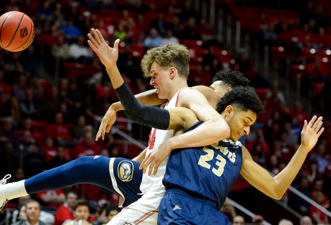 (Steve Griffin  |  The Salt Lake Tribune)  Utah Utes forward Jayce Johnson (34) battles UC Davis Aggies forward A.J. John (25) and UC Davis Aggies guard Rogers Printup (23) during the Utah versus UC Davis men's NIT basketball game at the Huntsman Center in Salt Lake City Wednesday March 14, 2018.