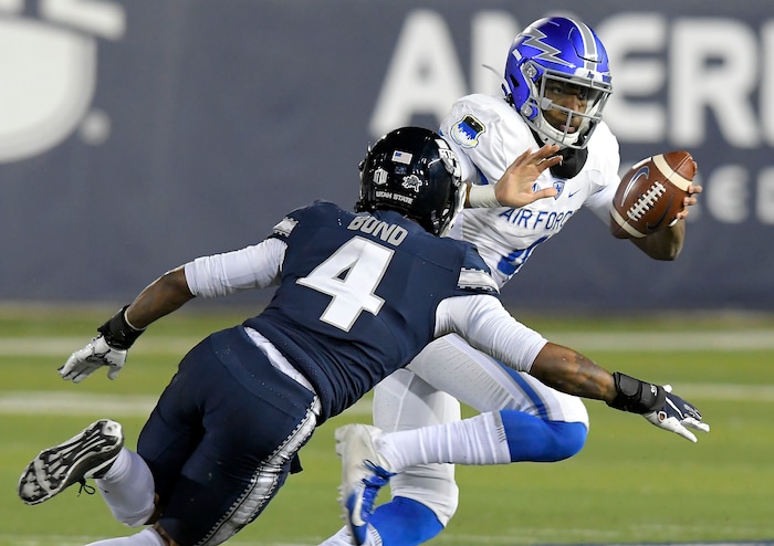 Air Force quarterback Haaziq Daniels, right, carries the ball as Utah State safety Shaq Bond defends during the first half of an NCAA college football game Thursday, Dec. 3, 2020, in Logan, Utah. (Eli Lucero/The Herald Journal via AP, Pool)