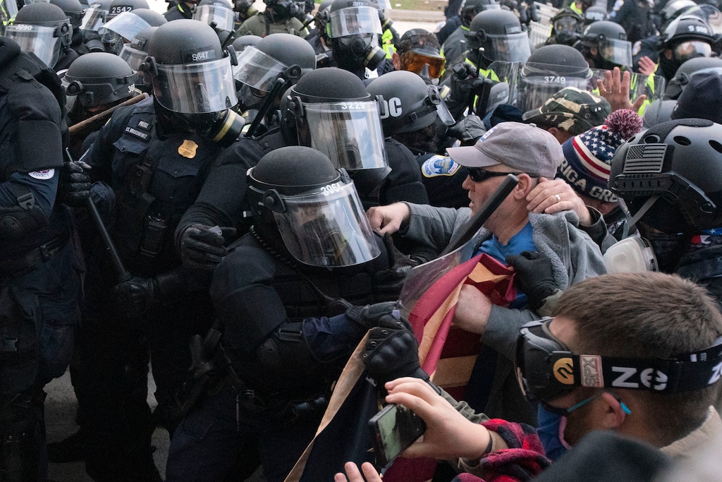 (Jose Luis Magana | AP photo) Capitol police officers in riot gear push back demonstrators who try to break a door of the U.S. Capitol on Wednesday, Jan. 6, 2021, in Washington.