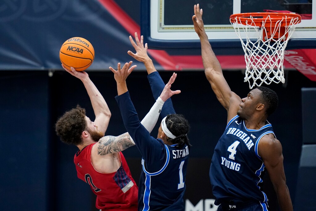 (Godofredo A. Vásquez | AP) Saint Mary's guard Logan Johnson, left, shoots over BYU guard Trey Stewart (1) and forward Atiki Ally Atiki during the second half of an NCAA college basketball game in Moraga, Calif., Saturday, Feb. 18, 2023.