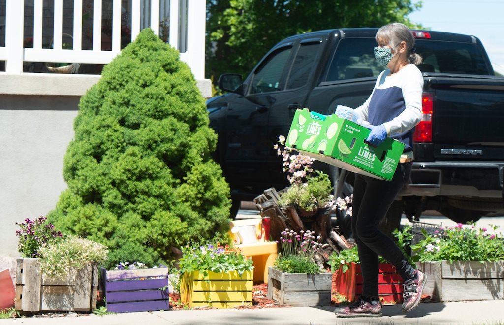 (Rick Egan  |  The Salt Lake Tribune)     Volunteer Sue Sanborn delivers boxes of food — donated to the St. Thomas Aquinas Catholic Church in Hyde Park — to a family impacted by the COVID-19 outbreak at the JBS Beef Plant in Hyrum, Thursday, June 18, 2020.