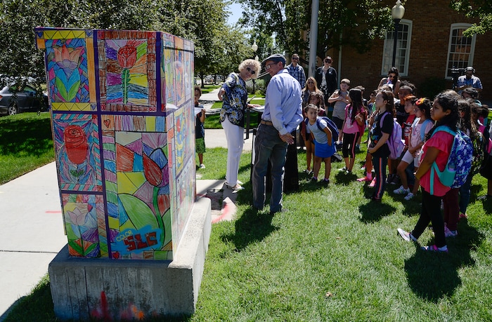 (Francisco Kjolseth  |  The Salt Lake Tribune)  Mayor Jackie Biskupski joins Bennion Elementary art teacher Paul Heath as he talks about his students art work that now decorates a utility box near the school. Salt Lake City schools alongside Bennion Elementary school kids and the mayor unveiled the final phase of its ColorSLC program, on Tuesday, Aug. 20, 2019, in which artwork from each of the district's elementary schools decorated utility boxes near each school.