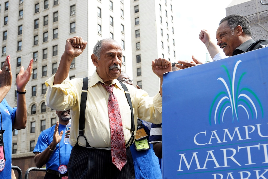 (Clarence Tabb, Jr. | Detroit News via AP, file photo) Congressman John Conyers, left, greets the Rev. Jesse Jackson, right, as postal workers rally to save Saturday mail service at the Campus Martius Park, in Detroit. Detroit police say the former congressman died at his home on Sunday, Oct. 27, 2019. He was 90.