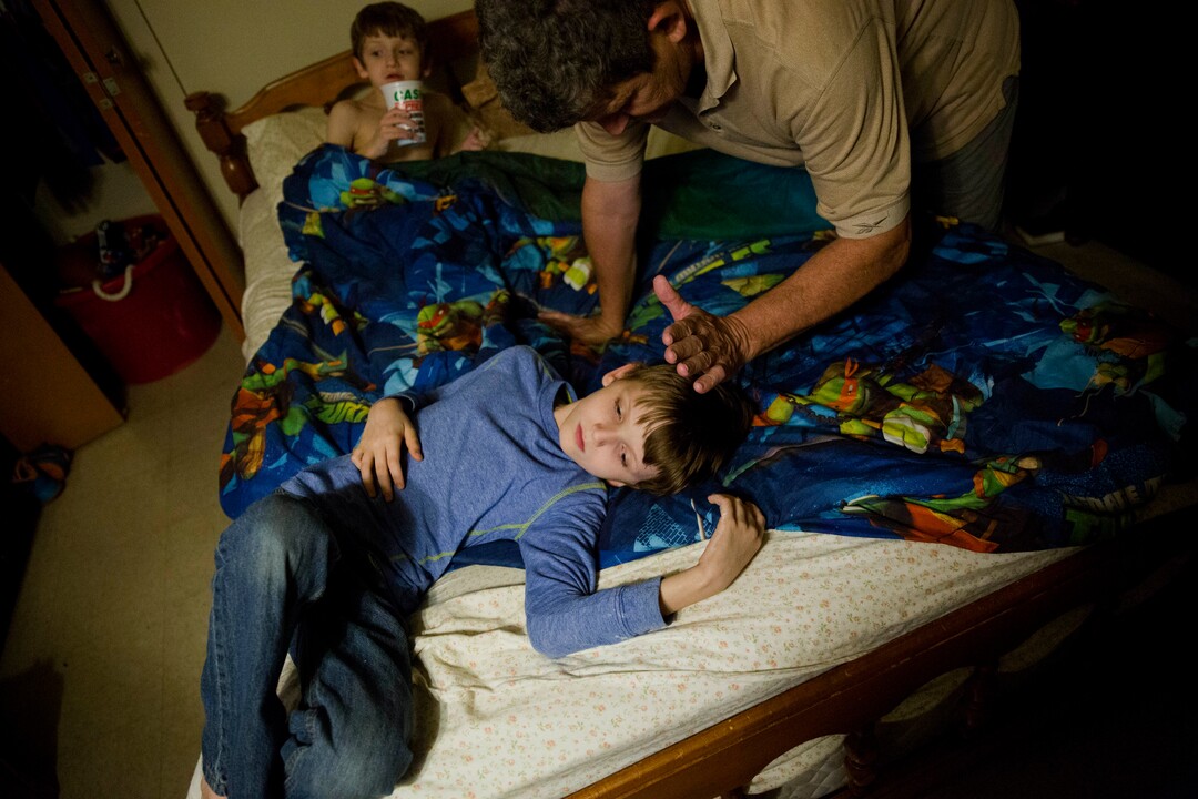 Danny Peters, 61, gets his sons Journey, 10, and Chance, 8, background, ready for bed in LaFollette, Tenn., Wednesday, March 28, 2018, as he cares for them while his ex-wife and the boys' mother, Crystal French, serves time in the Campbell County Jail. "It's been tough. She was a supermom," said Peters. "That's probably when it hurts the most. A mommy's love is the thing I can't give them." (AP Photo/David Goldman)