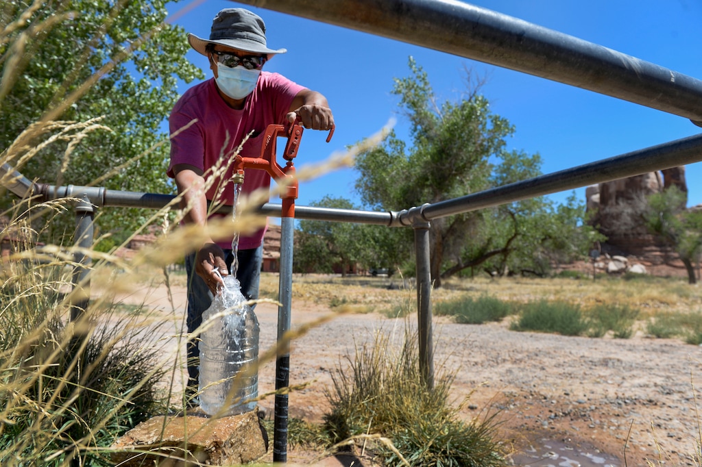 (Leah Hogsten | The Salt Lake Tribune) A man who lives in Aneth fills up his water jugs at the St. Christopher's Episcopal Mission well in Bluff. More than 30% of Navajo Nation households lack running water, and the problem is even worse in San Juan County where nearly half of Navajo Nation residents have to haul water. Families fill jugs at communal wells or buy bottled water from stores — both costly and time-consuming burdens that have become only more difficult during the pandemic.