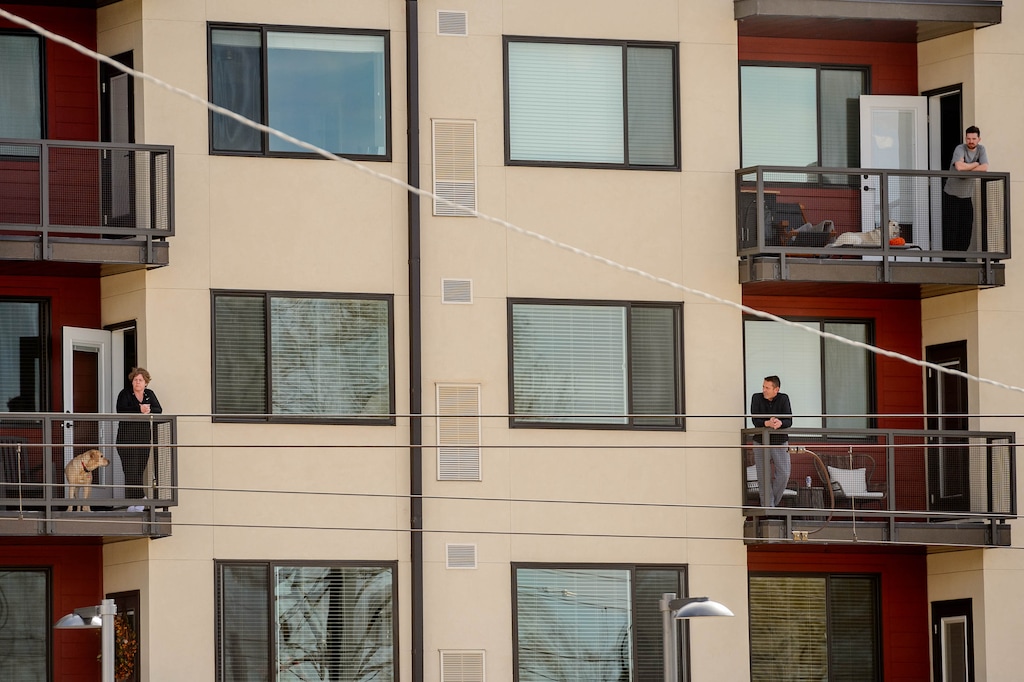 (Trent Nelson  |  The Salt Lake Tribune) Citizens practicing social distancing on their balconies at The Zeller Apartments in Salt Lake City on Monday, March 30, 2020.