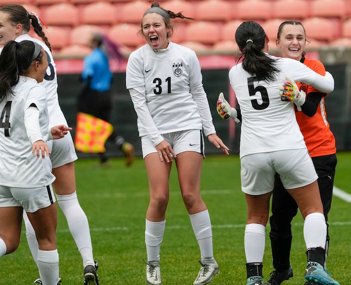 (Leah Hogsten | The Salt Lake Tribune)  Ogden's Sae Obayashi (5) and Kallie Cherry (31) celebrate goalie Emily Blackford after she punched away a penalty kick in the second half. Ogden High School defeated Morgan High School, 1-0, to win the 3A State Soccer Championship game Oct. 23, 2021 at Rio Tinto Stadium.