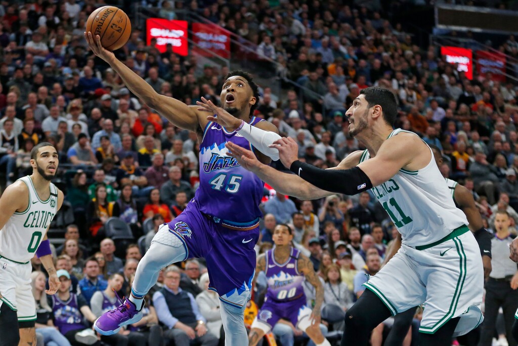 Utah Jazz guard Donovan Mitchell (45) goes to the basket as Boston Celtics center Enes Kanter (11) defends during the first half of an NBA basketball game Wednesday, Feb. 26, 2020, in Salt Lake City. (AP Photo/Rick Bowmer)
