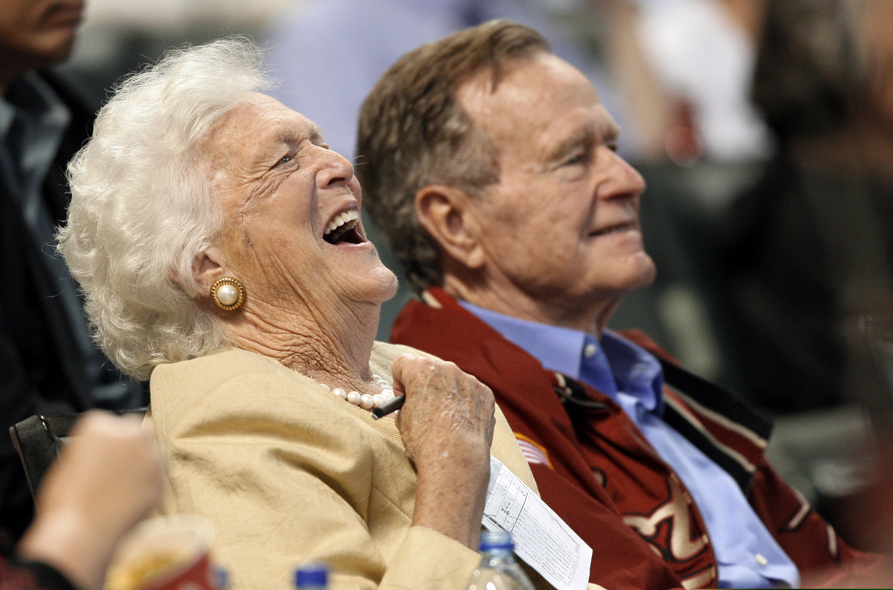 FILE - In this April 18, 2009, file photo, Barbara Bush laughs alongside former President George H.W. Bush, right, as they attend a baseball game in Houston. Barbara Bush, the snowy-haired first lady whose plainspoken manner and utter lack of pretense made her more popular at times than her husband, President George H.W. Bush, died Tuesday, April 17, 2018. She was 92. (AP Photo/David J. Phillip, File)