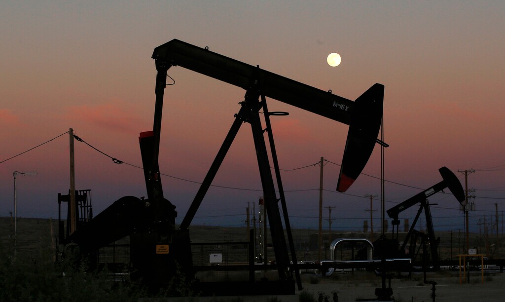 (Gary Kazanjian | AP file photo)  Oil derricks are busy pumping as the moon rises near the La Paloma Generating Station in McKittrick, Calif., on June 8, 2017.
