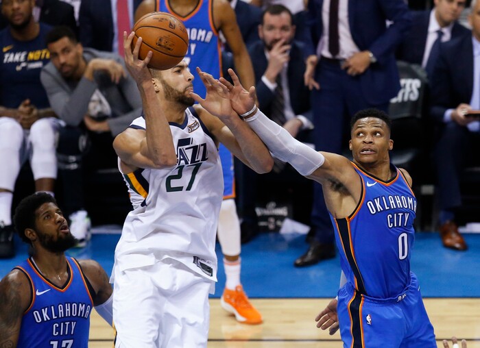 Utah Jazz center Rudy Gobert (27) grabs a rebound between Oklahoma City Thunder forward Paul George, left, and guard Russell Westbrook during the first half of Game 5 of an NBA basketball first-round playoff series in Oklahoma City, Wednesday, April 25, 2018. (AP Photo/Sue Ogrocki)