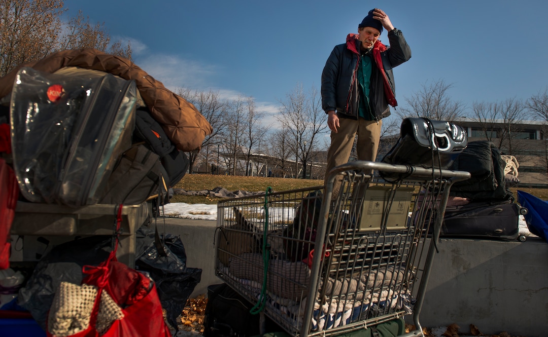 (Leah Hogsten  |  The Salt Lake Tribune)  Ron Barrett is overwhelmed as he looks over the four shopping carts that contain his and his wife's belongings. Hours before, police officers told the homeless couple to move their tent and belongings two times during the night or risk getting another 'no camping' ticket. Ron's goal was to re-pack the tent they've been living in Salt Lake City, get organized and downsize for easier mobility, but sleep deprivation and anxiety from the night's events wore him down.  "They [police officers] call our tent the "Hobo Palace," Barrett said.