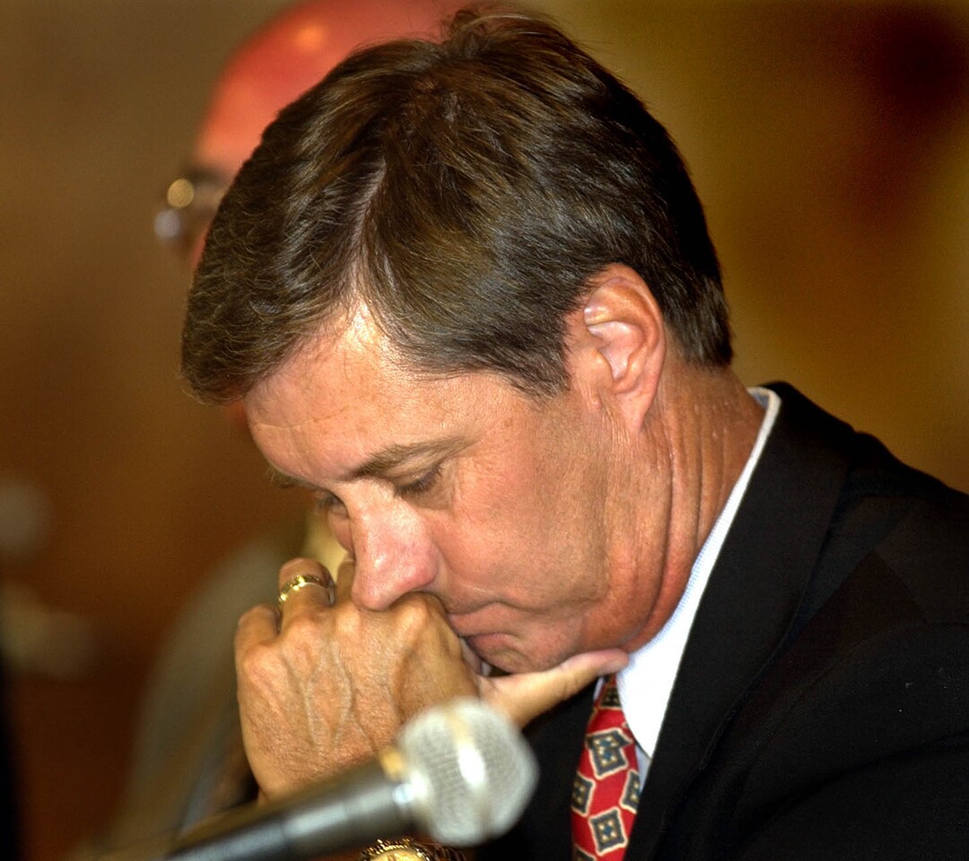 (Tribune File Photo)  Athletic Director Dr. Chris Hill listens as Coach Rick Majerus talks to the media at a press conference dealing with NCAA sanctions on July 30, 2003.
