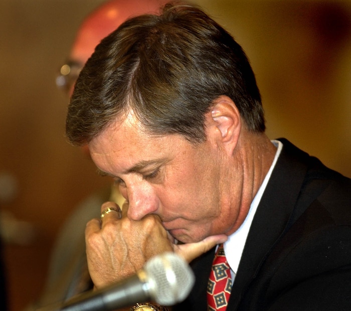 (Tribune File Photo)  Athletic Director Dr. Chris Hill listens as Coach Rick Majerus talks to the media at a press conference dealing with NCAA sanctions on July 30, 2003.