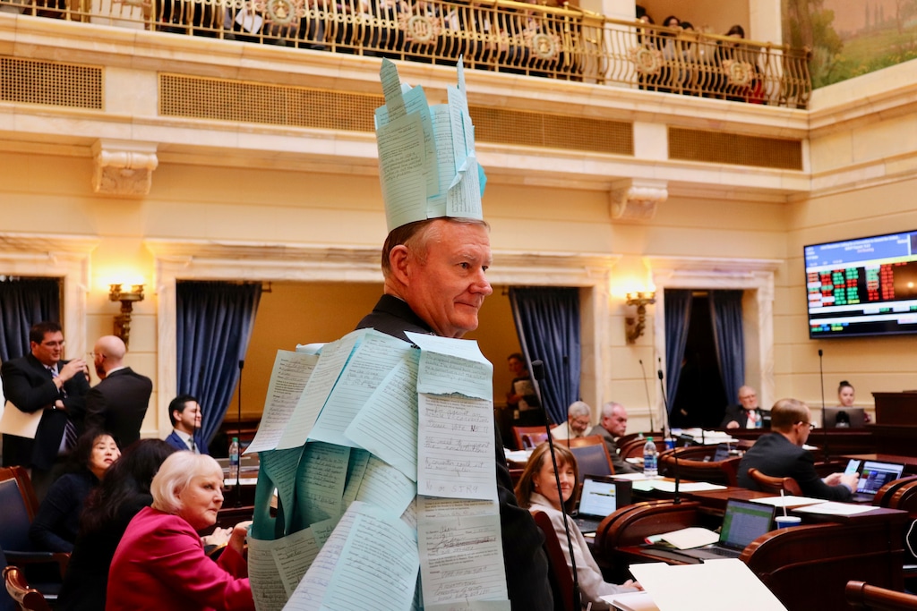 (Photo courtesy of Utah Senate) Sen. Evan Vickers, R-Cedar City, speaks in support of his resolution calling for a convention of states to consider amendments to the U.S. Constitution on Feb. 27, 2019. During his presentation, Vickers was draped with a cape and crown made of "blue notes," or messages from constituents who either support or oppose his resolution.