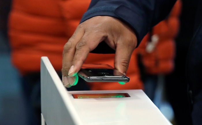 A shopper scans an Amazon Go app on a cellphone while entering an Amazon Go store, Monday, Jan. 22, 2018, in Seattle. The artificial intelligence-powered store, which opened to the public on Monday, allows shoppers to scan their smartphone with the Amazon Go app at a turnstile, pick out the items they want and leave. The online retail giant can tell what people have purchased and automatically charges their Amazon account. (AP Photo/Elaine Thompson)