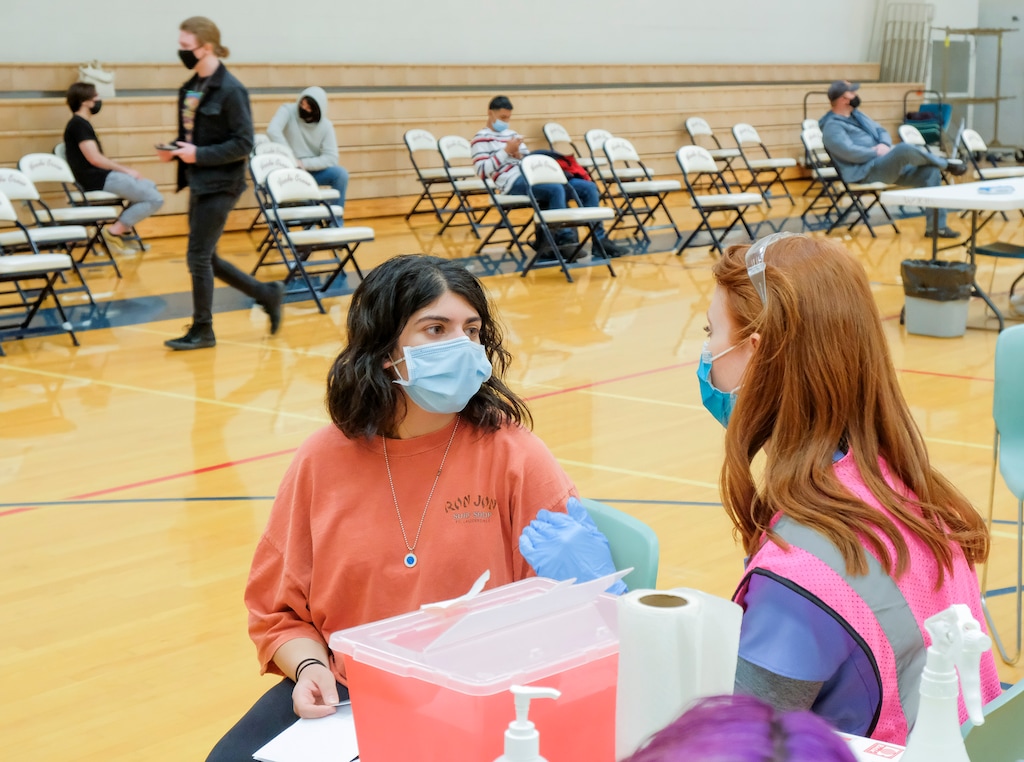 (Leah Hogsten | The Salt Lake Tribune) Sara Sharma, 16, a student at Woods Cross High School, misses her Spanish class to receive her first Pfizer vaccine from pharmacist Shannon Stoker at a pop-up clinic by Nomi Health,  April 27, 2021.