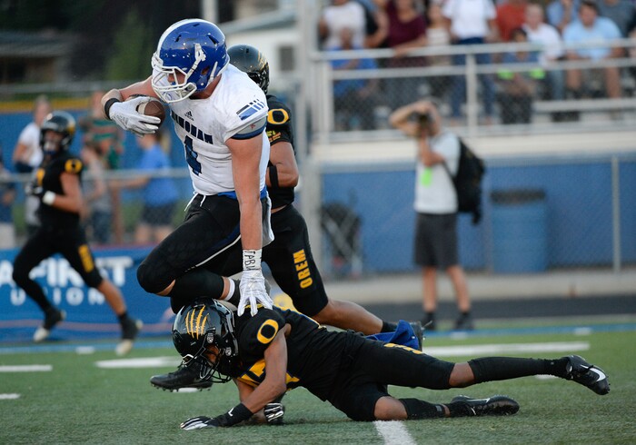 (Francisco Kjolseth  |  The Salt Lake Tribune)  Bingham's Briasen Harward runs over Orem's Jakob Robinson as he nears the end zone,  Thursday, Aug. 16, 2018 in Orem.