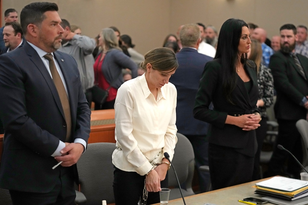 (Rick Bowmer | The Associated Press)Kouri Richins, center, a Utah mother of three who authorities say fatally poisoned her husband then wrote a children's book about grieving, lowers her head following a bail hearing Monday, June 12, 2023, in Park City, Utah. A judge ruled to keep her in custody for the duration of her trial.