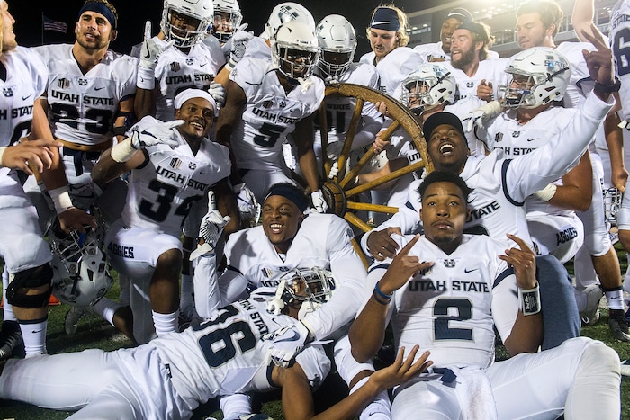 (Chris Detrick  |  The Salt Lake Tribune)  Utah State Aggies pose for pictures with the Old Wagon Wheel after the game at Merlin Olsen Field at Maverik Stadium Friday, September 29, 2017. Utah State Aggies defeated Brigham Young Cougars 40-24.