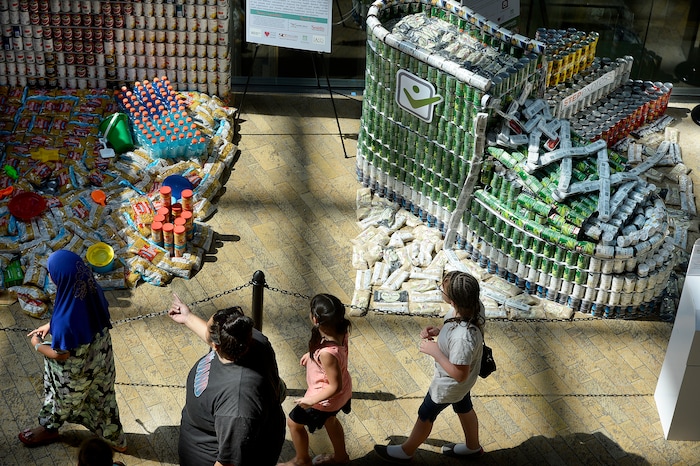 (Scott Sommerdorf | The Salt Lake Tribune) Visitors to the Salt Lake City Public Library walk past the stepexpress.com shoe made out of cans and sardines for he laces as the library hosted a community display and food drive focused on healthy food items for the Utah Food Bank. Teams from six local health careÐrelated businesses built giant sculptures using healthy canned, bagged, and boxed foods. The replica of Rice-Eccles Stadium won the public choice award, Thursday, August 10, 2017.