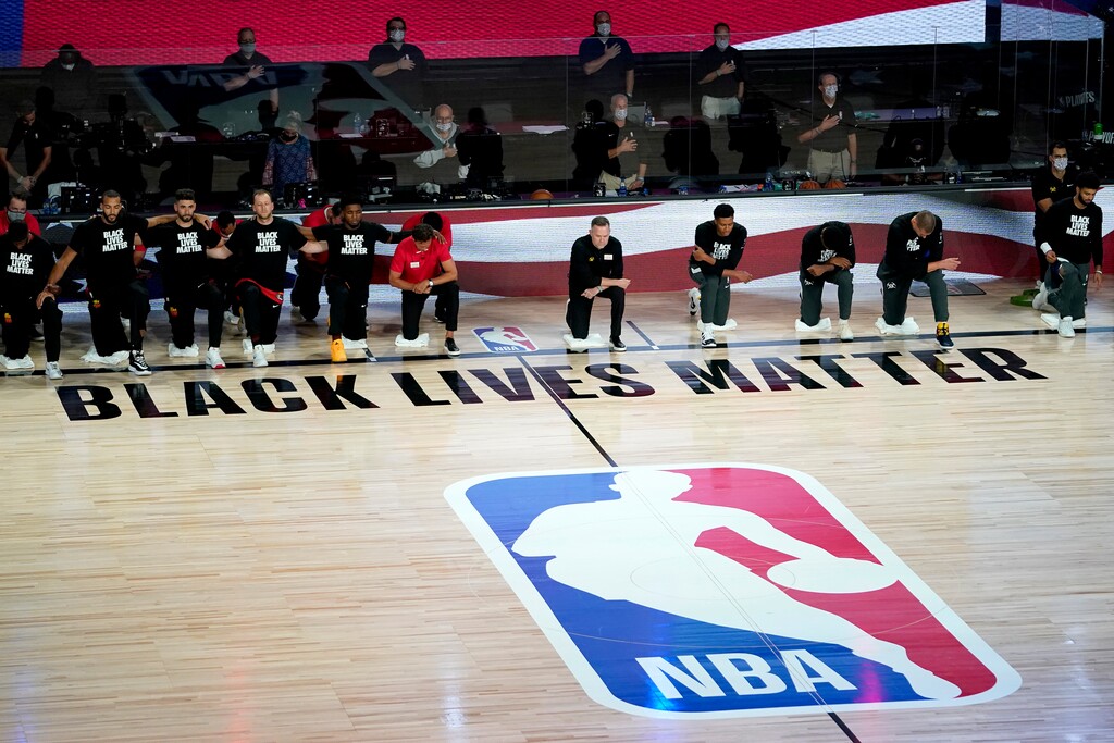 The Utah Jazz, left, and the Denver Nuggets kneel during the national anthem prior to an NBA basketball first round playoff game Friday, Aug. 21, 2020, in Lake Buena Vista, Fla. (AP Photo/Ashley Landis, Pool)