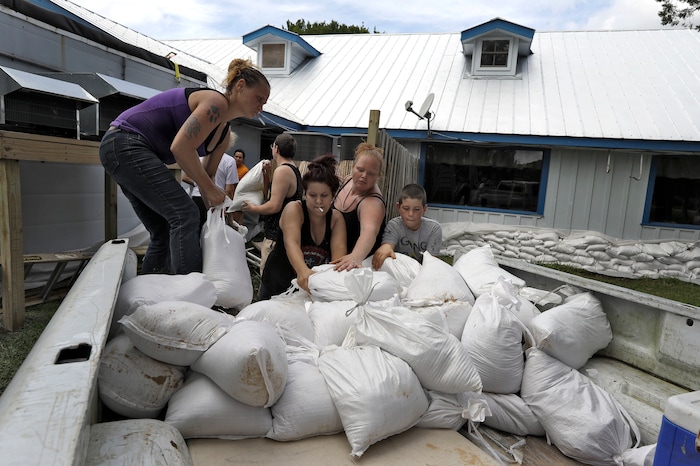 (Chris O'Meara | The Associated Press) Krystal Day, of Homosassa, Fla., left, leads a sandbag assembly line at the Old Port Cove restaurant Tuesday, Oct. 9, 2018, in Ozello, Fla. Employees were hoping to protect the restaurant from floodwaters as Hurricane Michael continues to churn in the Gulf of Mexico heading for the Florida panhandle.