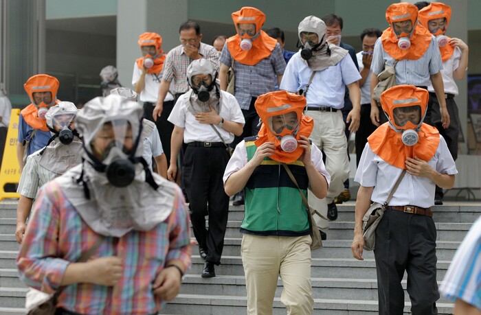 FILE- In this Aug. 18, 2010, file photo, South Koreans wearing gas masks escape from a mock smoke attack during an anti-terror exercise carried out as part of Ulchi Freedom Guardian exercise, against possible attacks from North Korea in Seoul, South Korea. The Ulchi Freedom Guardian drills set to begin Monday, Aug. 21, 2017 will be the first joint military exercise between the allies since North Korea successfully flight-tested two intercontinental ballistic missiles in July and threatened to bracket Guam with intermediate range ballistic missile fire in August. (AP Photo/Lee Jin-man, File)