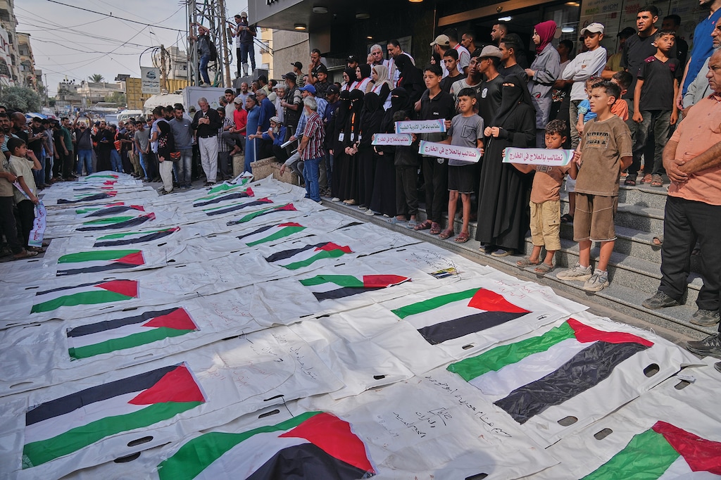 Mourners gather around the flag-draped remains of Palestinians killed in Israeli strikes after they were recovered from the rubble, during their funeral in Nuseirat, Gaza Strip, Tuesday, Sept. 29, 2026. (AP Photo/Jehad Alshrafi)