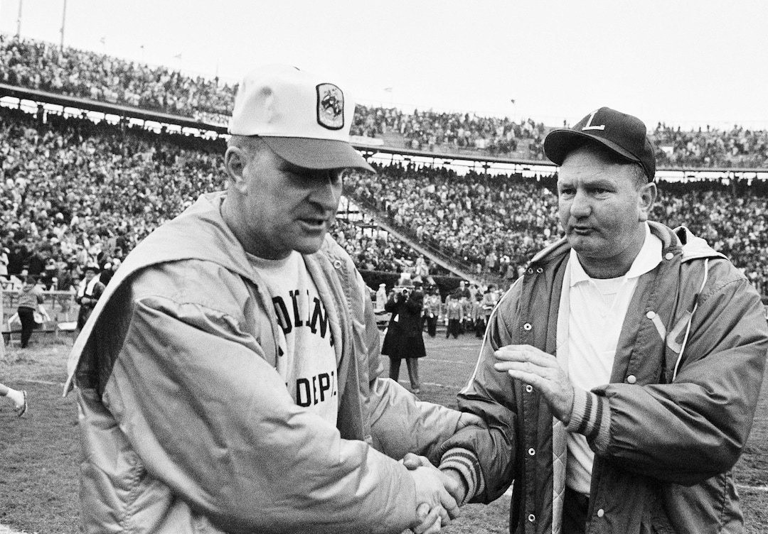 (AP file photo) In this Jan. 1, 1968, file photo, LSU coach Charlie McClendon, right, pats the hand of Wyoming coach Lloyd Eaton in the Sugar Bowl at New Orleans. The University of Wyoming is welcoming eight former football players back on campus half a century after a racist episode gutted their team. University officials plan to unveil a plaque commemorating the Black 14 athletes at War Memorial Stadium on Friday, Sept. 13, 2019. Eaton dismissed the 14 black players after they asked Eaton if they could wear black armbands to protest racism. Black 14 members say their biggest disappointment is not hearing Eaton explain himself. Eaton died in 2007.